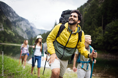 Group of young friends hiking in countryside. Multiracial happy people travelling in nature