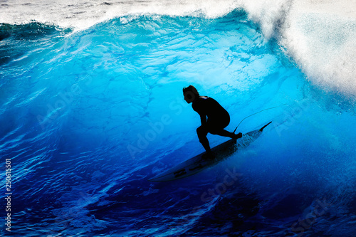 Silhouette surfer riding the big blue surf waves on the island Madeira, Portugal, a popular surfing tourist destination