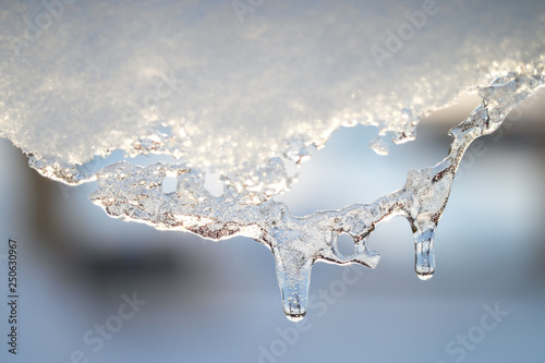 Snow melting icicle spring background.