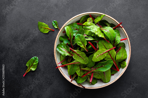 Fresh chard leaves on black background top view