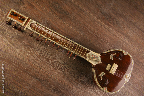 Indian musical instrument sitar lying on the wooden floor