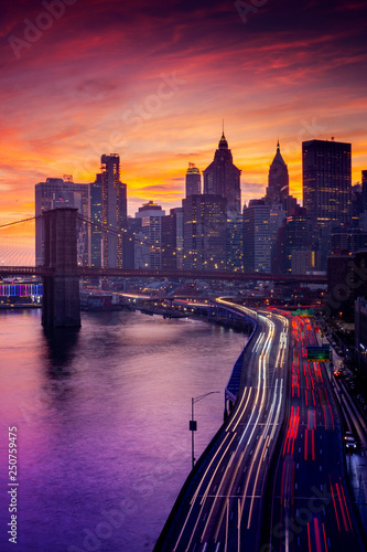 Must see when visiting New York City. View of Lower Manhattan and Brooklyn at sunset. Night scene. Light trails. City lights. Urban living, travel, real estate and transportation concept
