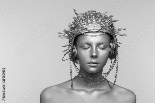 Futuristic woman in metal helmet with screws, nuts and chains