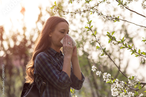 Woman blowing nose because of spring pollen allergy