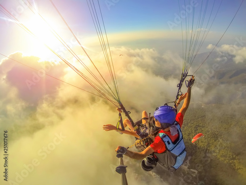 Paragliding in the sky. Paraglider tandem flying over the sea with blue water and mountains in bright sunny day. Aerial view of paraglider and Blue Lagoon in Oludeniz, Turkey. Extreme sport. Landscape