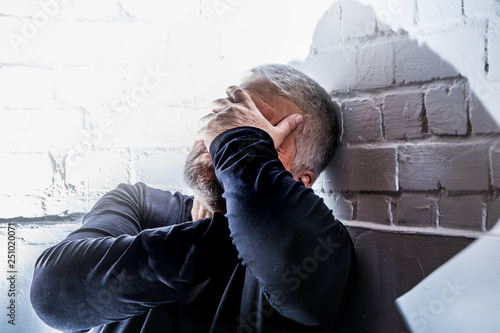 a desperate man holds his head with his hands