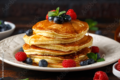 Homemade american pancakes with fresh blueberry, raspberries and honey. Healthy morning breakfast. rustic style