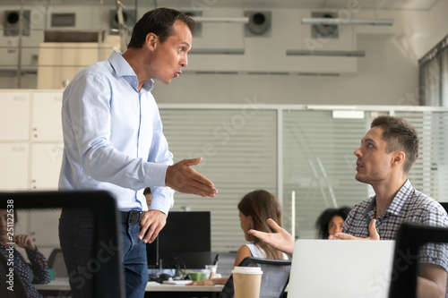 Angry millennial colleagues arguing in office workplace