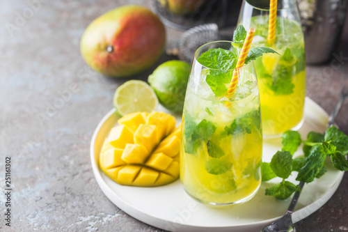 Fresh mango mojito cocktail with lime and mint in a glass