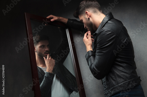 narcissist sexy young man admiring himself in the mirror