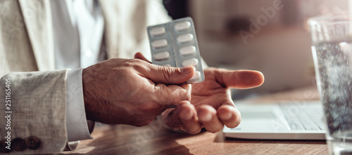 Businessman taking medical pills in the office