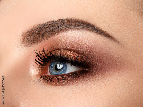 Close-up of woman eye with beautiful brown smokey eyes makeup