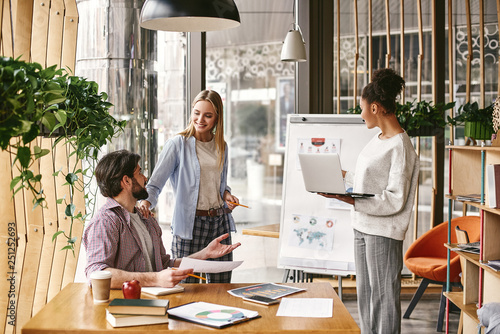 Discussing company progress. Three co-workers are comparing results and developing a strategy