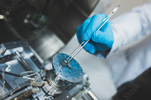 Researcher, scientist, physicist or laboratory assistant working, experimenting and analyzing in modern lab with equipments, tools and machines.