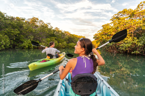 Couple kayaking together in mangrove river of the Keys, Florida, USA. Tourists kayakers touring the river of Islamorada.