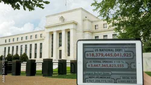 a debt clock and the exterior of the federal reserve building