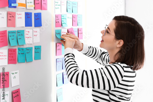 Young woman near scrum task board in office