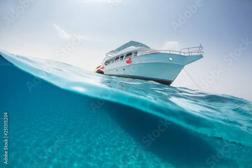Split photography of safari yacht and underwater