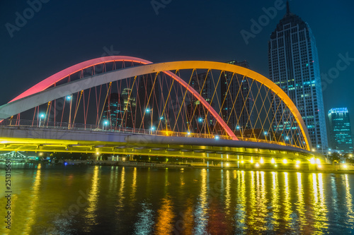 Tianjin Hai river waterfront downtown skyline with illuminated Dagu bridge,China