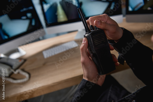 cropped view of guard holding walkie-talkie at workspace