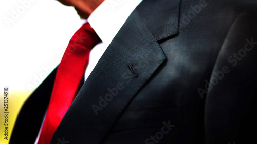 a black business suit jacket with white shirt and red tie, man neck and chest close up texture background with copy space.