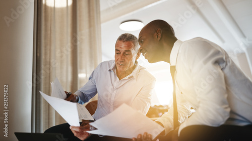 Two businessman discussing paperwork together in an office