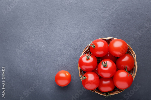 Cherry tomatoes in basket on black background