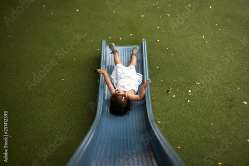 Niña jugando en un tobogan de un parque