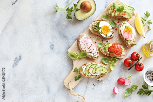 Breakfast sandwich bread with avocado, egg, radishes and tomatoes. Bruschetta or healthy snack ideas