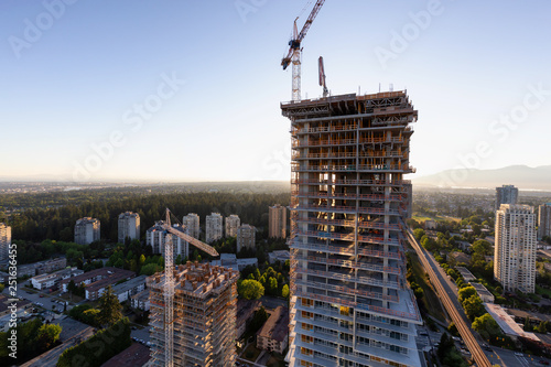 Aerial view of a residential building construction site during a vibrant summer sunset. Taken in Burnaby, Vancouver, BC, Canada.