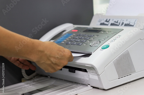 hand of man are using a fax machine in the office Business concept 