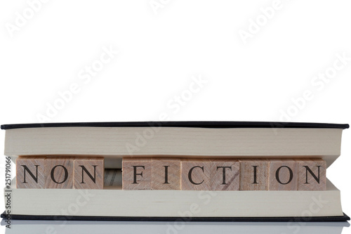 Non fiction written on wooden blocks inside a book isolated on a white background with reflection