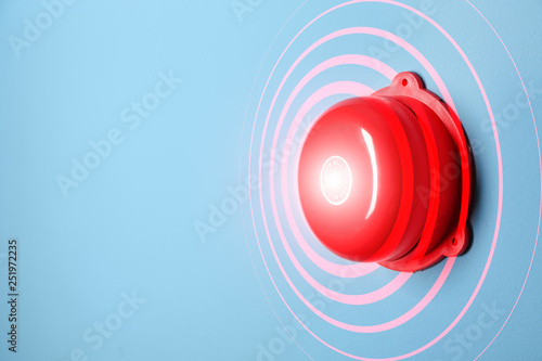 Modern alarm bell on color background