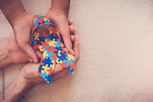 Hands holding puzzle ribbon, World Autism Awareness Day, Autism spectrum disorder