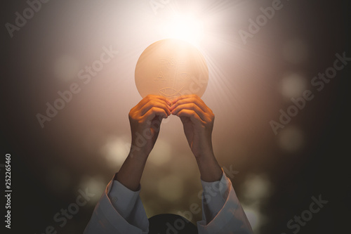 Pastor lifting a bright communion bread