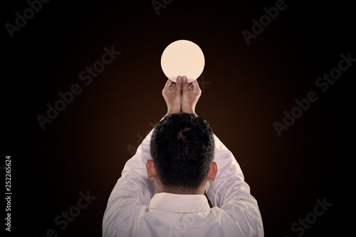 Pastor prays to God consecration a bread