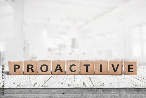 Proactive sign on a wooden table in a bright office