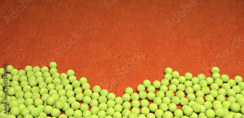 Plein de balles de tennis sur fond de terre battue