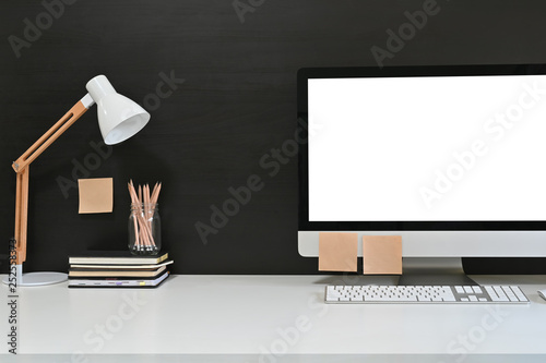 Workspace blank screen desktop computer, Mockup computer, lamp and home office accessories on white desk.