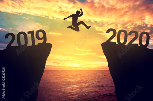 Businessman jump between 2019 and 2020 years.