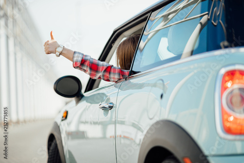 Woman in car driving on the road. Happy beautiful girl traveling in a car.