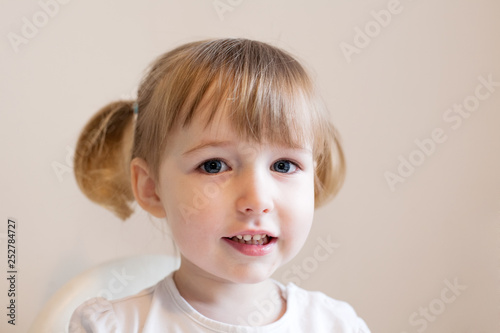 funny little girl with two cute pigtails face closeup
