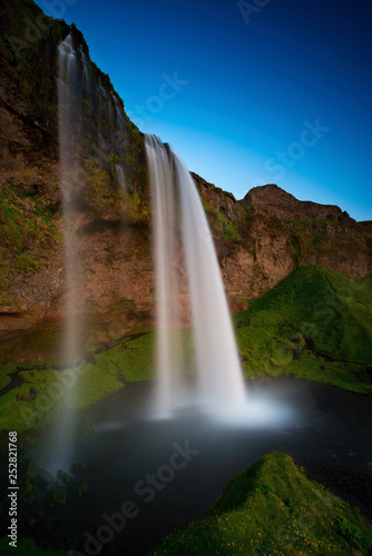 The Seljalandsfoss waterfall in the last golden light. One of the most famous waterfalls in Iceland.