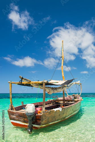 boat for walking in emerald sea under blue sky with clouds on Zanzibar island