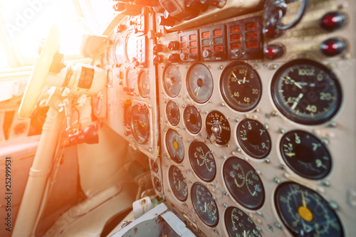 Dashboard of an old airplane. Many analog pointers, buttons and switches