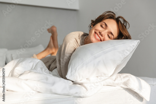 Smiling young girl relaxing in bed