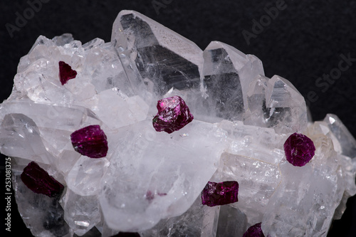 Top quality A grade small rough RUBY crystals from Tanzania on FADEN QUARTZ CLUSTER. Isolated on black background.