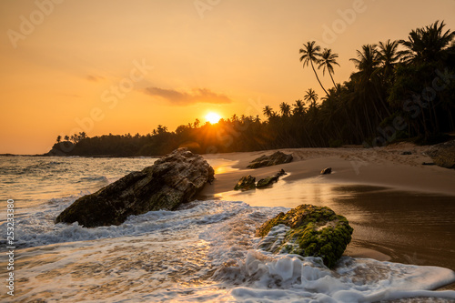 Beautiful sunset on the beach with palms on a Seychelles