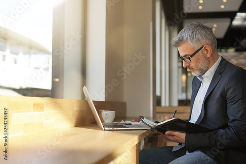 Businessman working with computer waiting for flight in modern airport