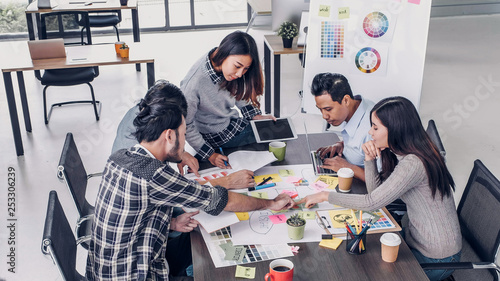 Female Creative director team leader brainstorm branding project with designer team at meeting table.discussion idea in creative office.